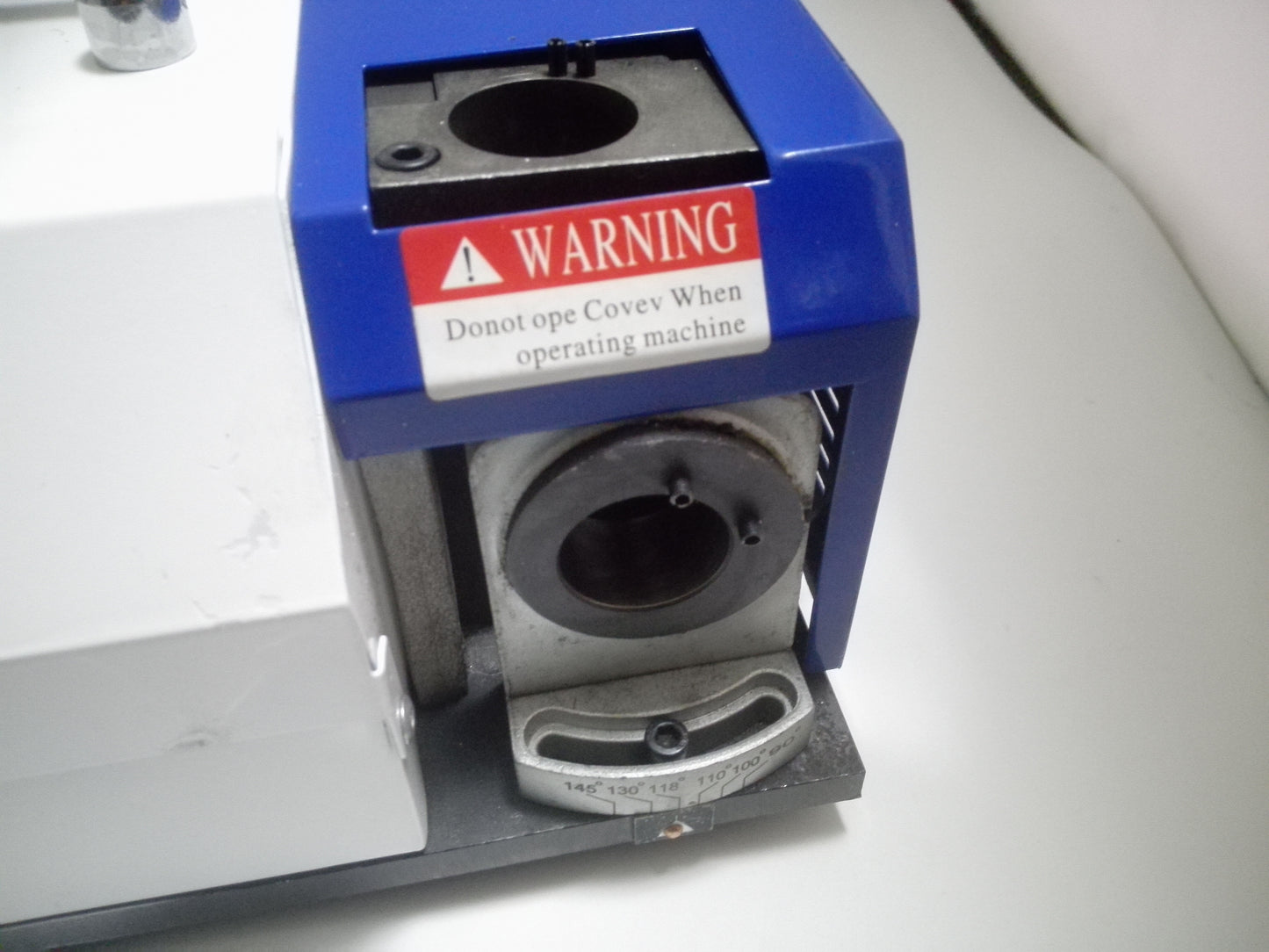 Drill bit grinding station with angle scale and warning cover