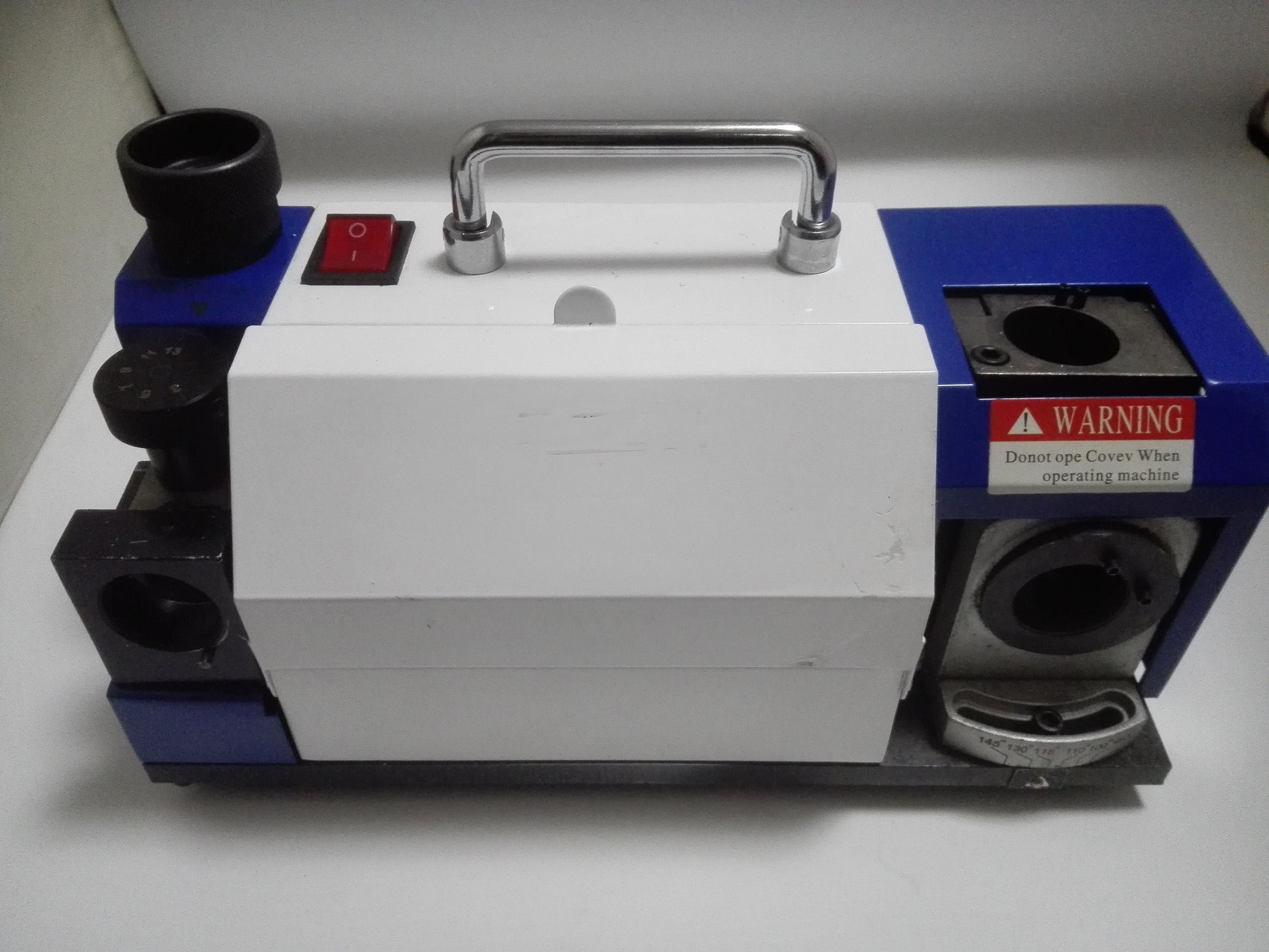 Open drill sharpening machine showing ER20 collets and angle scale