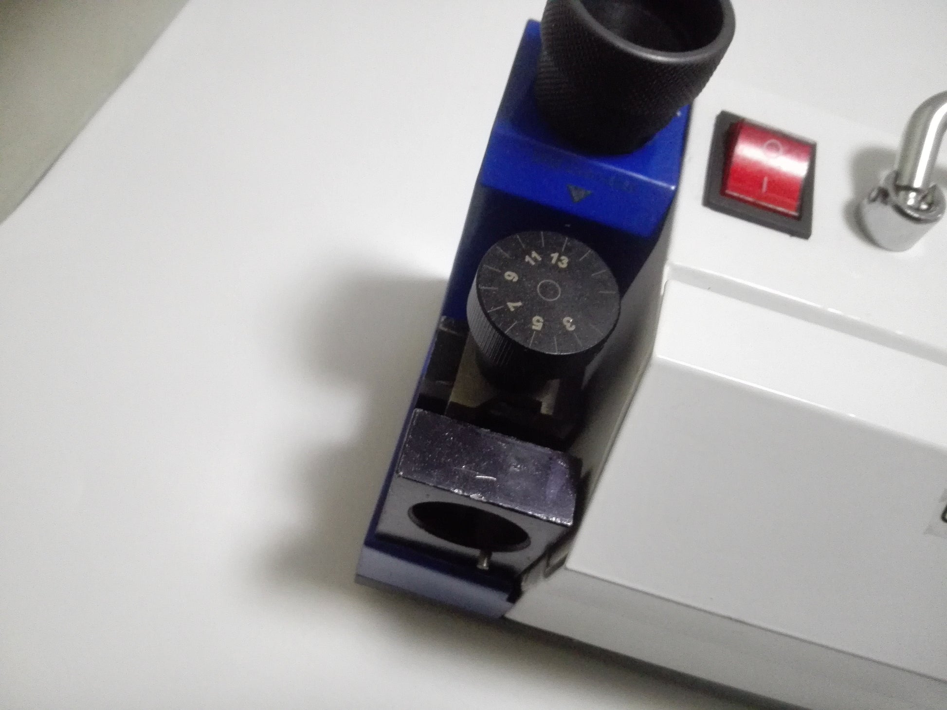 Drill bit setup dial and power switch on portable drill sharpener