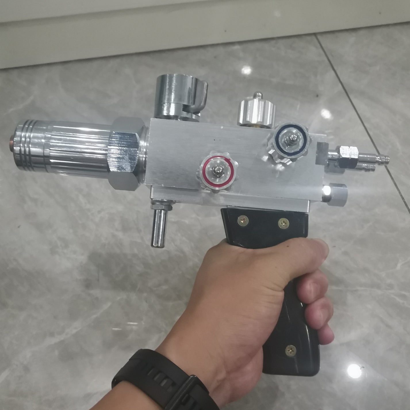 Powder spray welding torch handle with control knobs and gas fitting detail