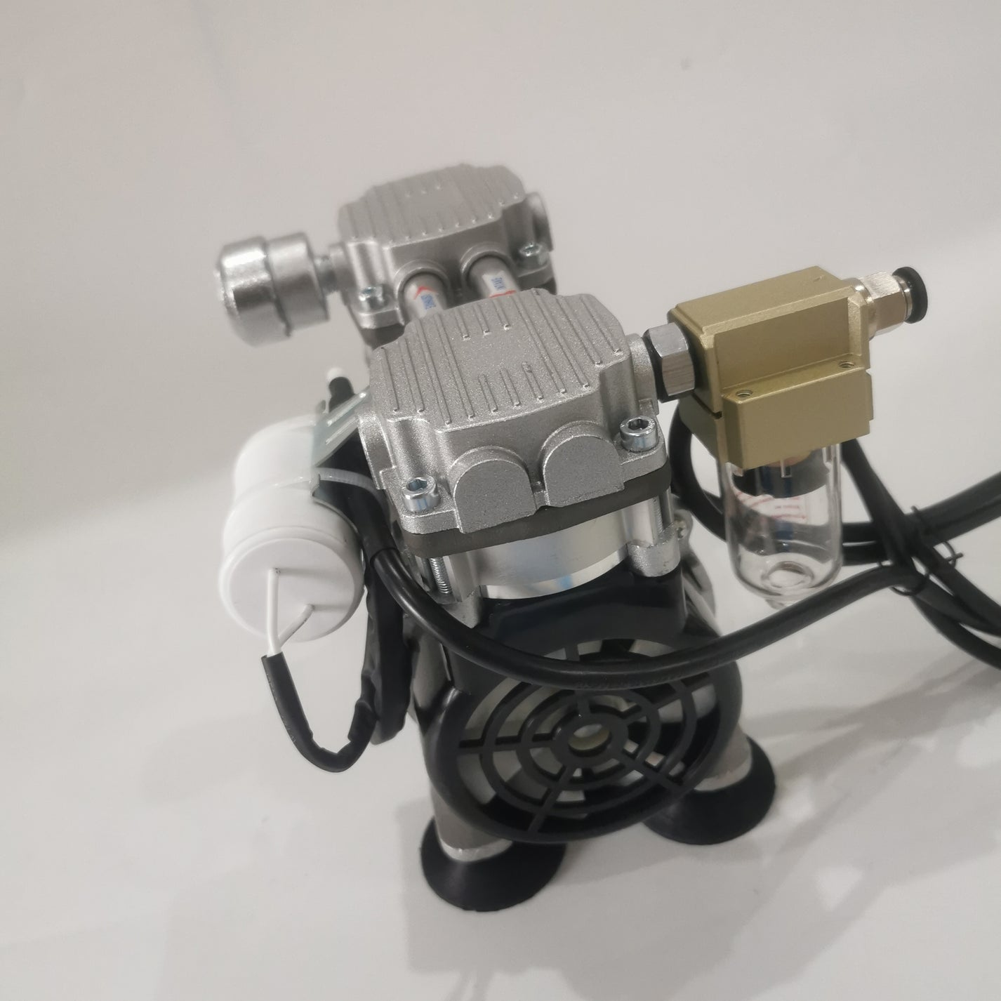 Top view of oil-free vacuum pump with filter, power cable and intake/exhaust tubes