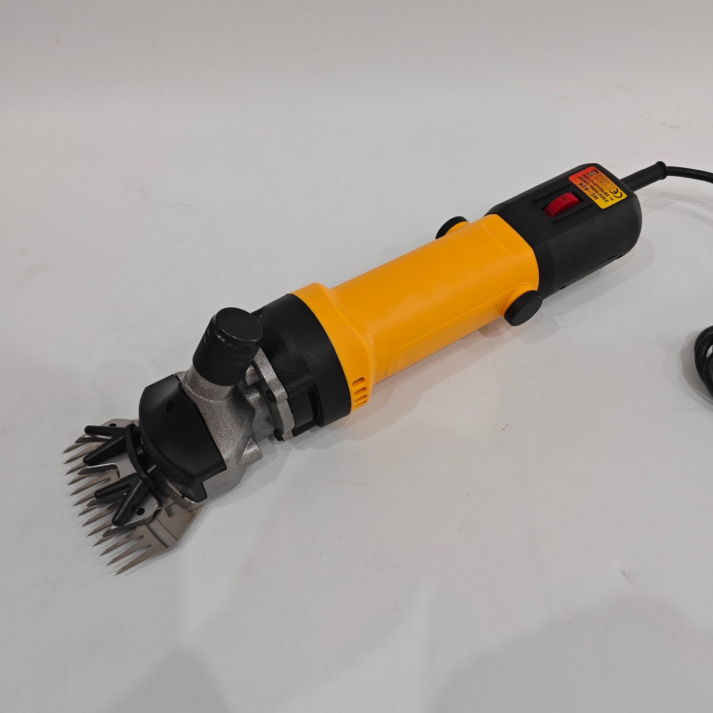 Angled view of 690W electric sheep shearing clipper with yellow handheld body