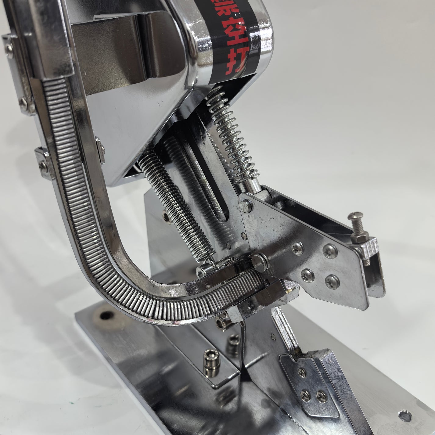 Close-up of manual sausage clipper spring and U-clip feed mechanism