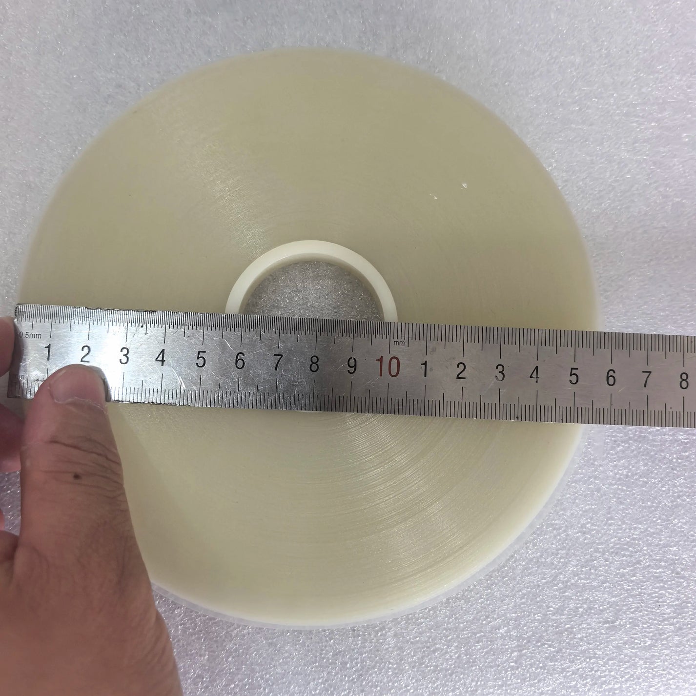 Ruler showing 155mm outer diameter of transparent OPP banding tape roll