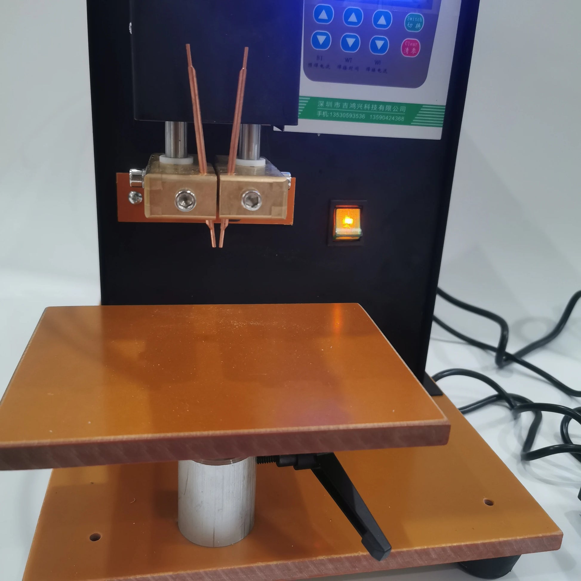 Close-up of copper electrodes and work table on pneumatic battery spot welder