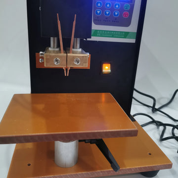 Close-up of copper electrodes and work table on pneumatic battery spot welder