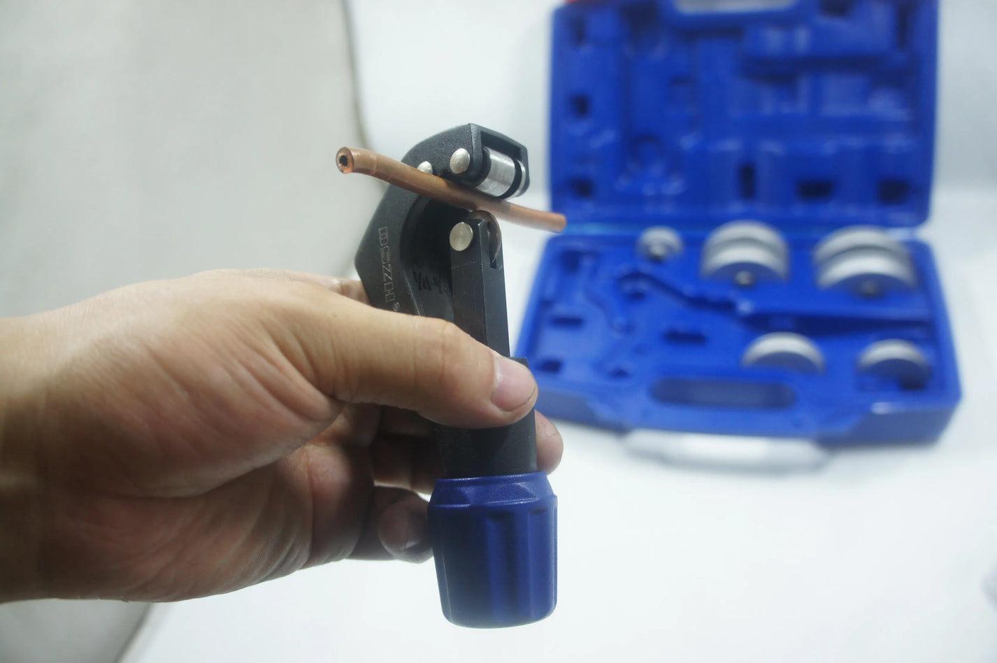 Tube cutter trimming copper tube beside the pipe bender kit case