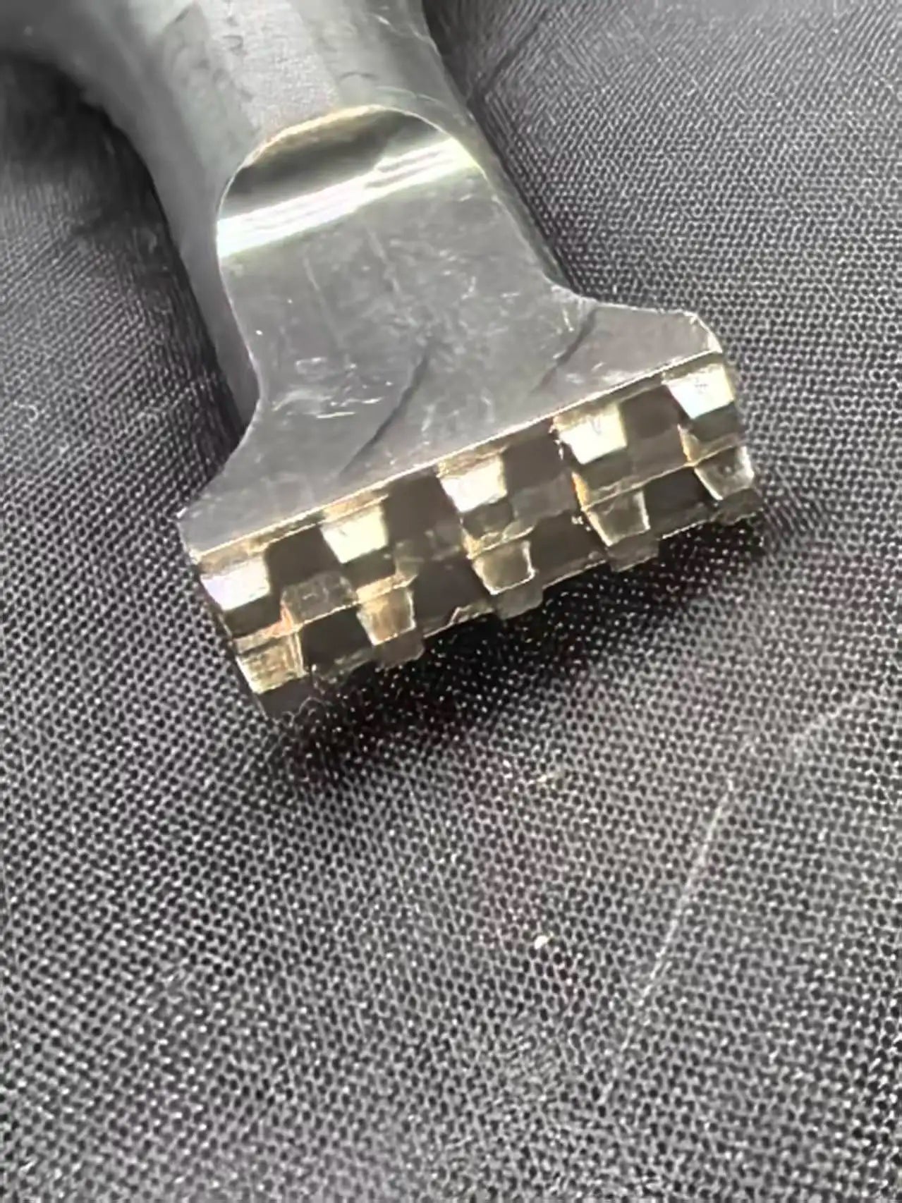Wide ultrasonic welding horn tip close-up on textured fabric
