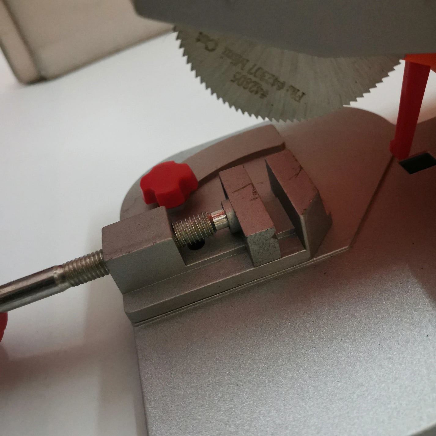 Close-up of 2 in blade, vise clamp, and miter scale on mini cut-off saw