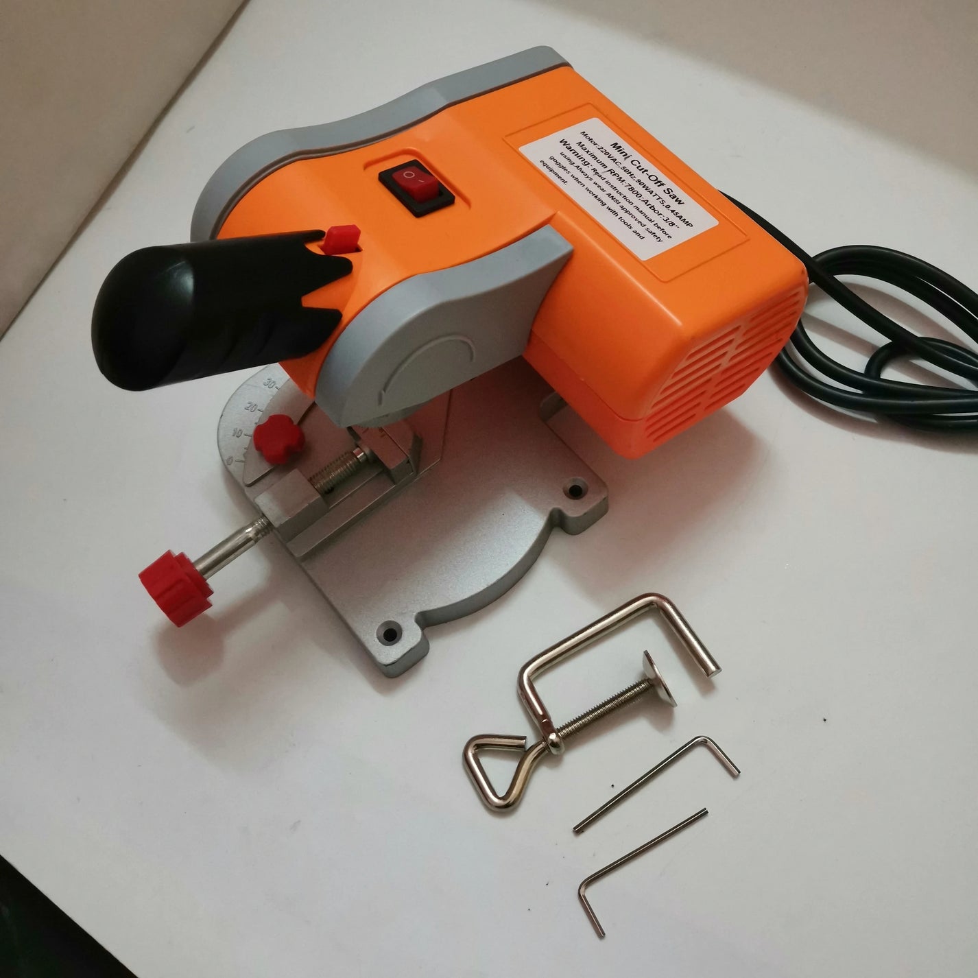 Mini bench cut-off saw with power cord, miter scale, clamp, and small tools